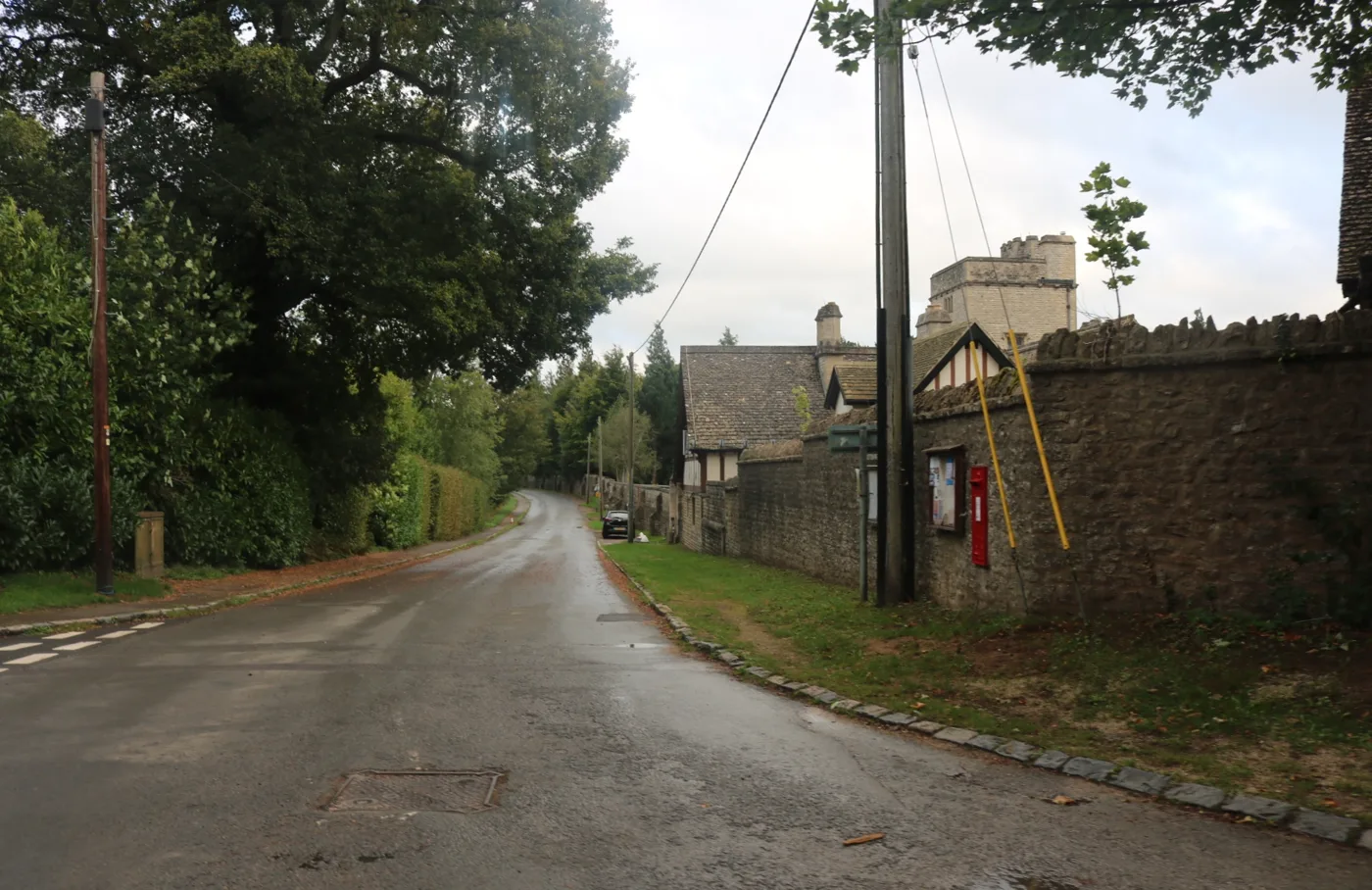 Foxcombe Hall's tower above its boundary wall on Boars Hill